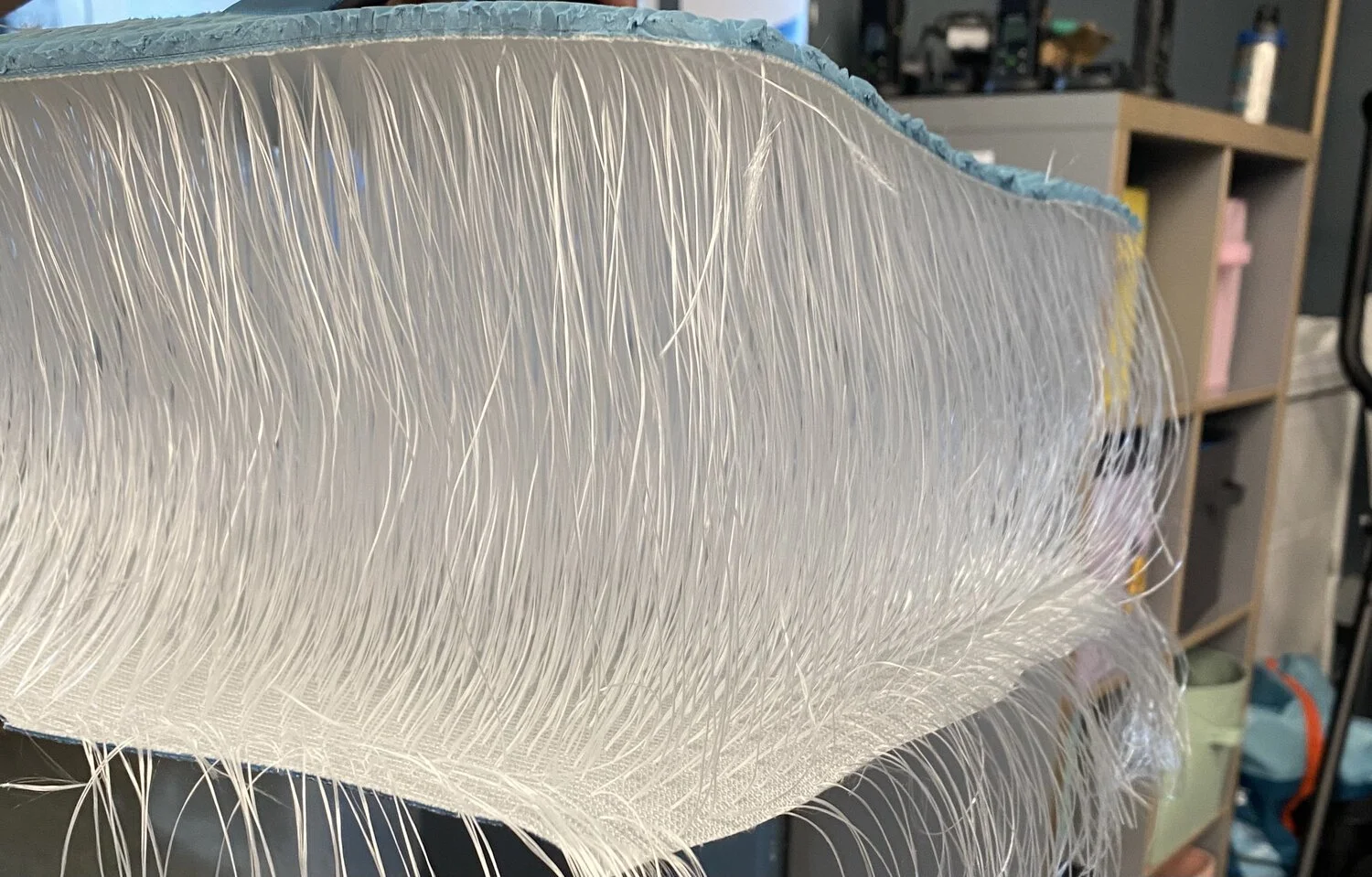 The cut-open edge of an inflatable paddleboard, showing the thousands of drop-stitch threads running between its top and bottom skins.