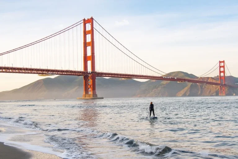 A lone paddler on the water with the Golden Gate Bridge behind.