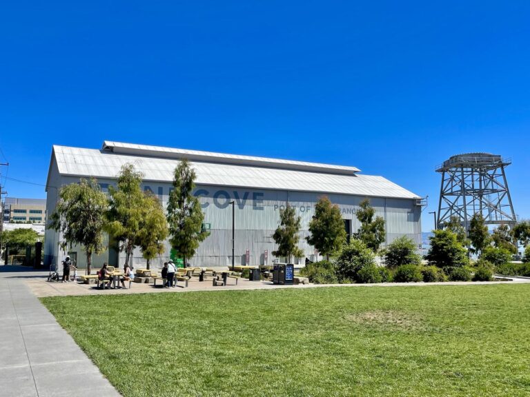 The lawn at Crane Cove Park with the shed and the gantry crane behind.