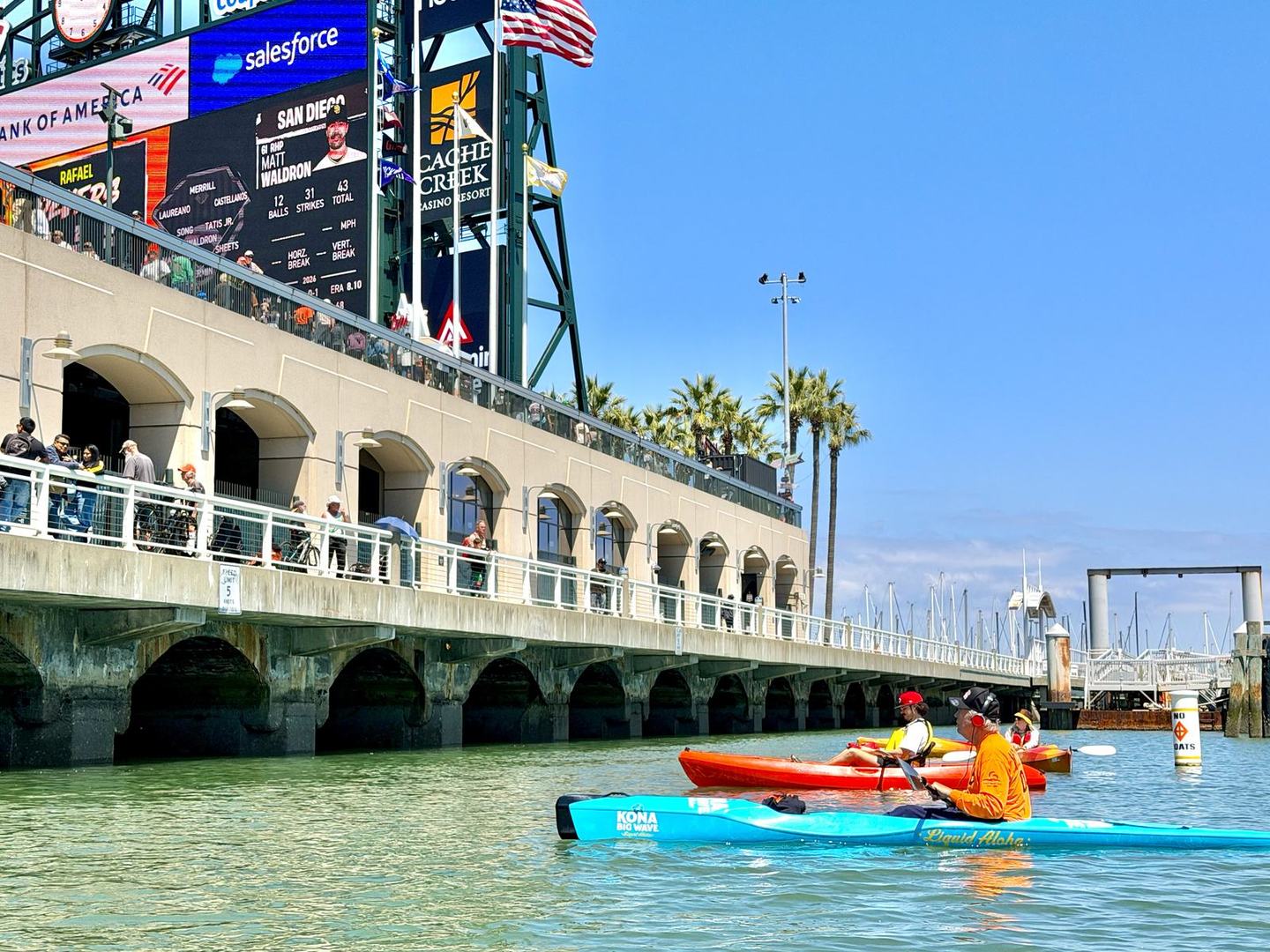 Kayakers on the water in McCovey Cove alongside the Oracle Park arcade during a Giants home game