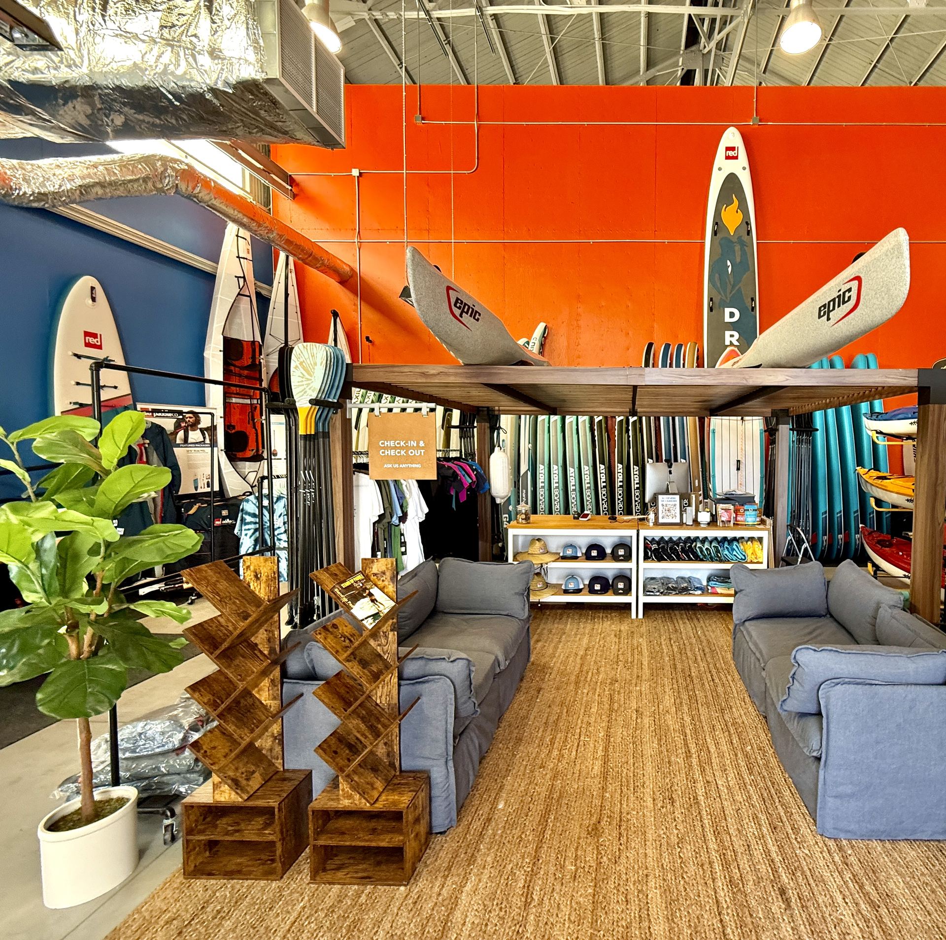 Stand-up paddle boards and kayaks racked along the walls of the Dogpatch Paddle shop in Building 49 at Crane Cove Park