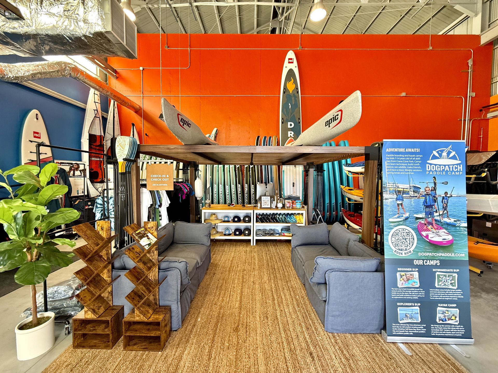 Inside the shop at Crane Cove, boards on the orange wall and the counter beyond.